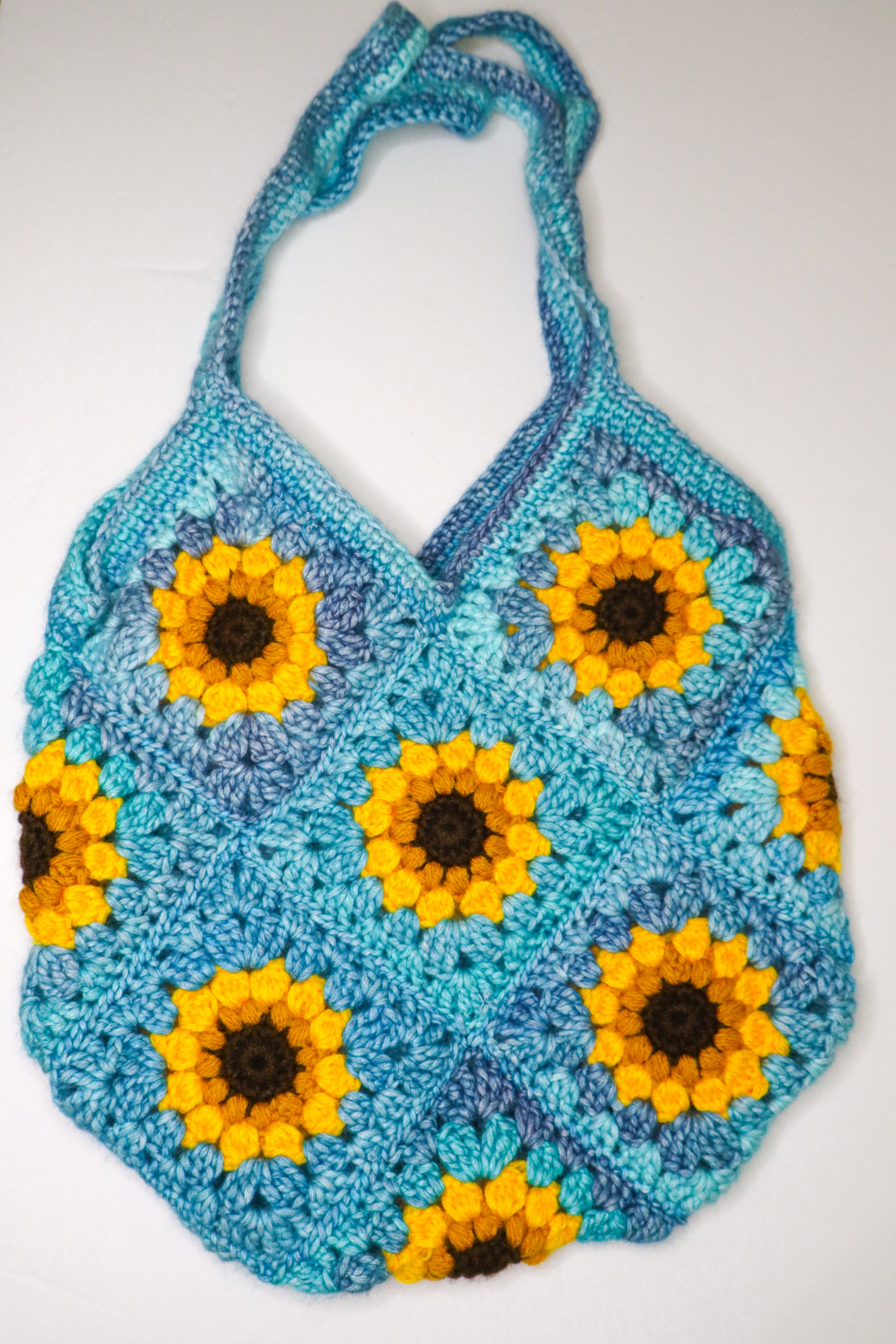 Crocheted bag with sunflower pattern on a white background