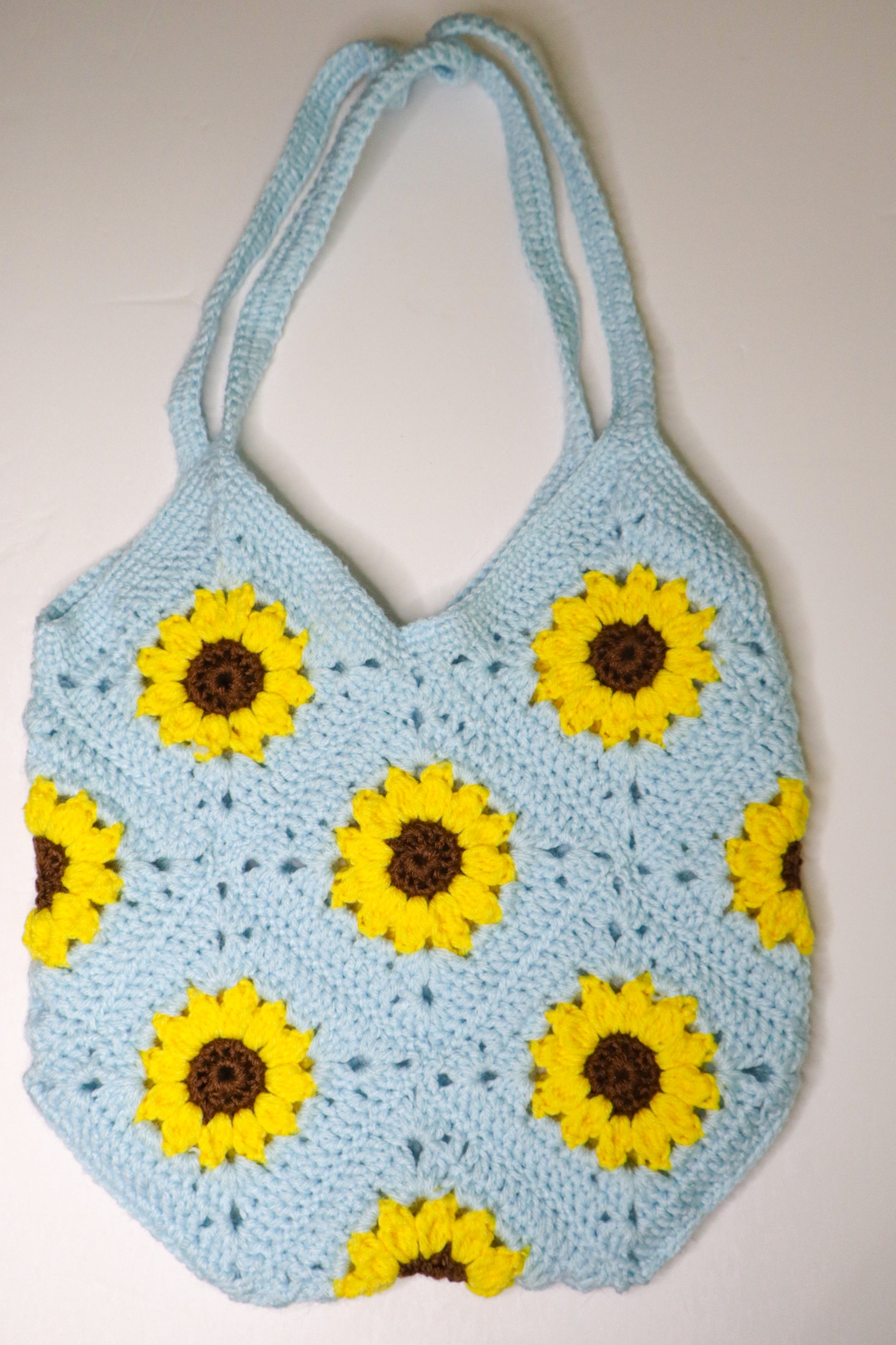 Crocheted bag with sunflower patterns on a beige background
