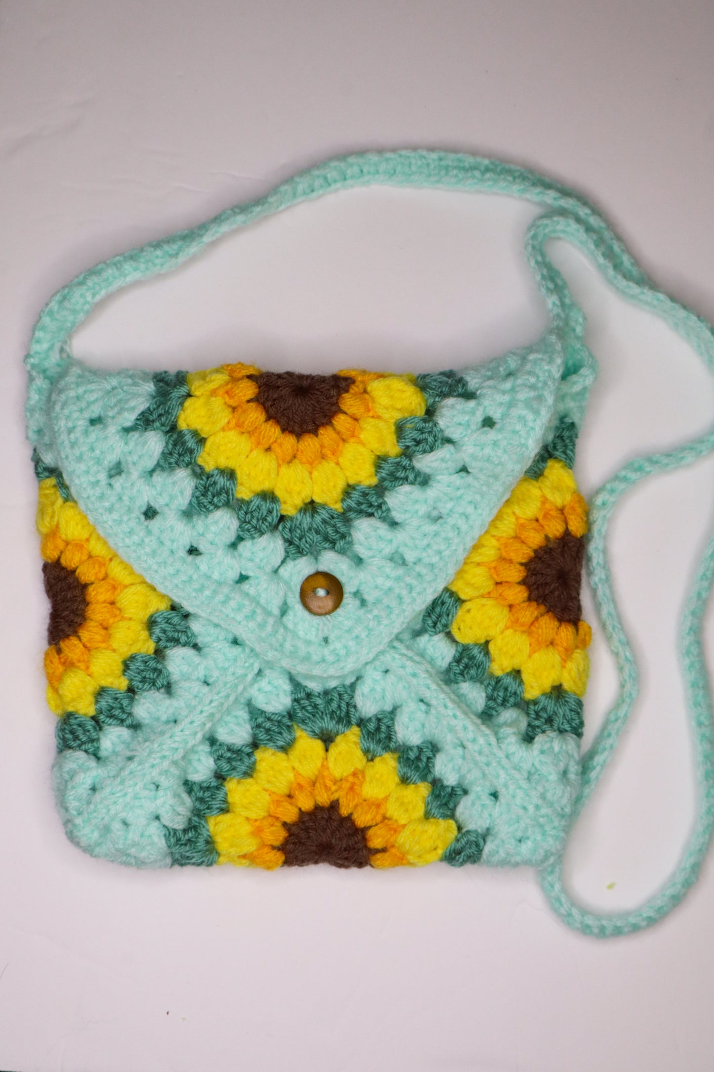 Crocheted bag with sunflower pattern on a white background