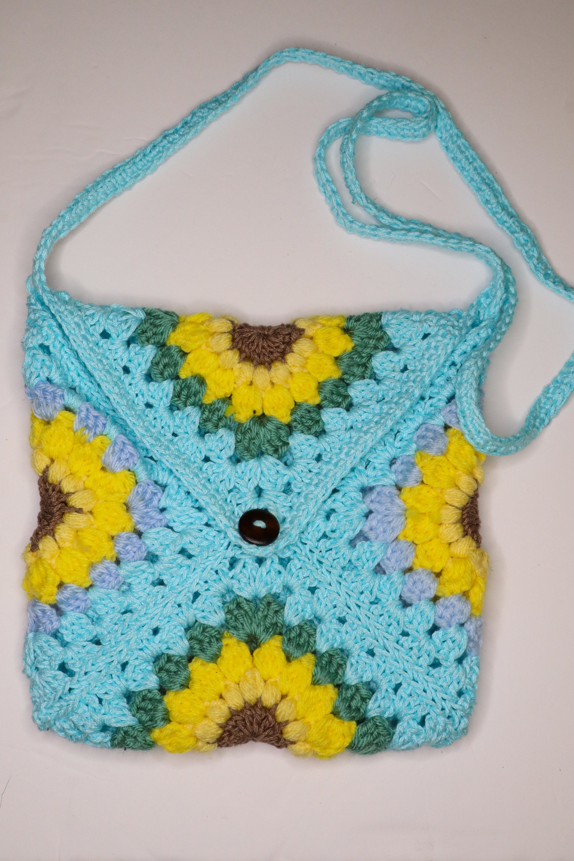 Crocheted bag with sunflower pattern on a white background