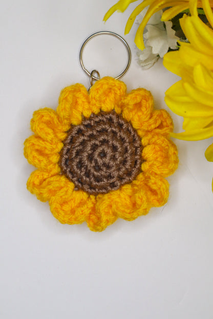 Crocheted sunflower keychain with brown center on a white background