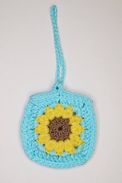 Crocheted bag with a sunflower design on a light gray background