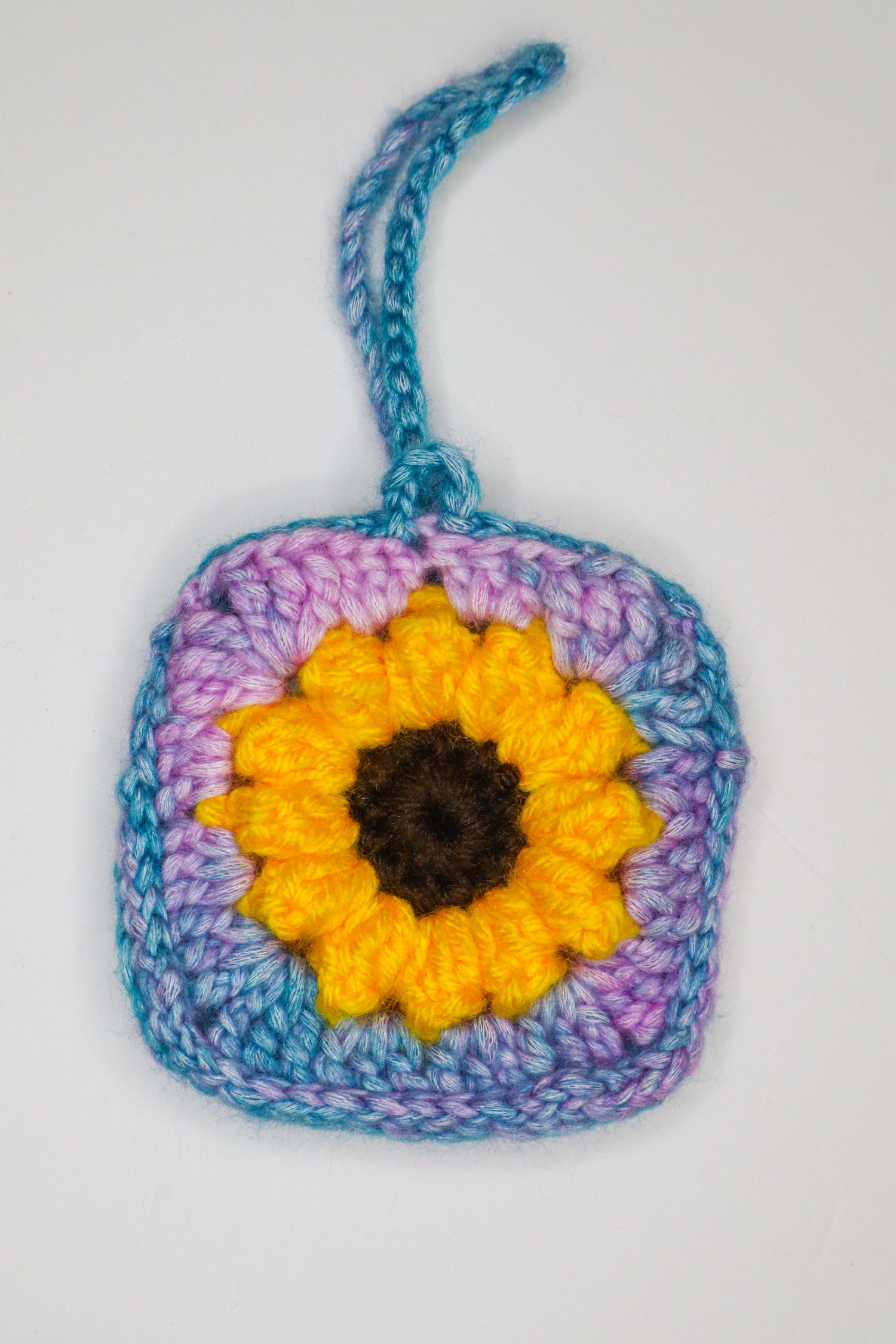 Crocheted square with a sunflower design on a white background