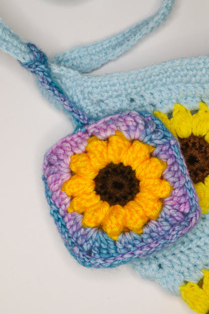 Crocheted flower with blue, purple, and yellow colors on a white background